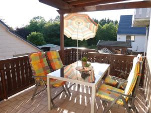 einen Tisch und Stühle auf einer Terrasse mit einem Sonnenschirm in der Unterkunft Wäller Ruh' in Pfuhl
