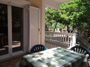 a table and chairs on a porch with a sliding glass door at Turtle Beach Apartment in Marathias