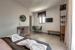 una camera da letto con un letto e un tavolo con sedie di Lofts to Let a Kalivia Poligirou