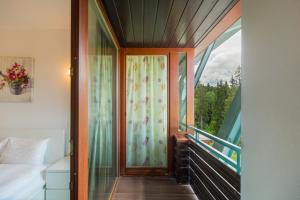 a room with a balcony with a bed and a window at Family Apartment in Silver Mountain Resort in Poiana Brasov