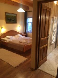 a bedroom with a bed and an open door at Termálvölgye Vendégház in Demjén