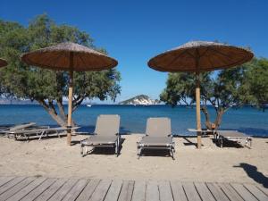 a group of chairs and umbrellas on a beach at Turtle Beach Apartment in Marathias