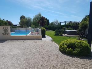 a backyard with a swimming pool and a garden at Gite - Studios Marie Barrault in Les Herbiers