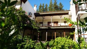 ein weißes Haus mit einem Balkon und Pflanzen in der Unterkunft Totelya Hotel in Akyaka