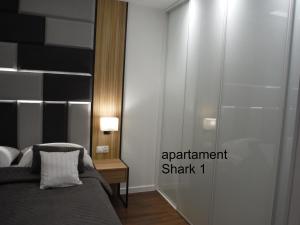 ギジツコにあるApartamenty Sharkのベッドルーム1室(ベッド1台付)、アパートメントサメを読む看板付きのドア