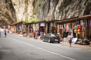 a street with a group of shops next to a mountain at Niki Apart Pension in Gheorgheni