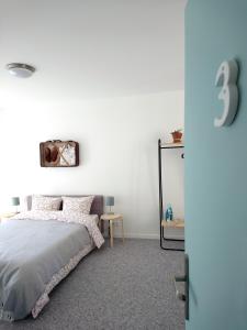 Habitación blanca con cama y espejo en Cool Places, en Limoges