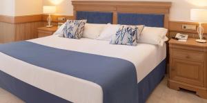 a bedroom with a large bed with blue and white pillows at SH Villa Gadea in Altea