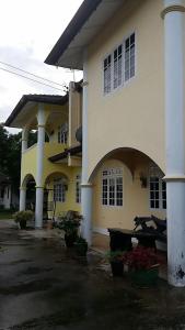 a large building with potted plants in front of it at Homestay Petrajaya Kuching in Kuching