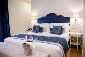 1 dormitorio con 1 cama grande con almohadas azules y blancas en San Gemini Palace en San Gemini