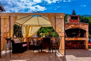 eine Terrasse mit einem Tisch und einem Kamin in der Unterkunft Comfortable apartment near Opatija in Matulji