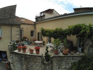 an outdoor patio with potted plants on a stone wall at Gîte de l’Eyrieux in Les Ollières-sur-Eyrieux