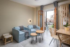 a living room with a couch and chairs and a table at Oasis Apartments in Tolo