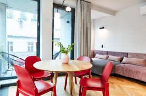 sala de estar con mesa y sillas rojas en Rajska Blue Luxury Apartment en Cracovia