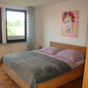 a bedroom with a bed and a painting on the wall at Gästewohnung am Grinderwald in Neustadt am Rübenberge