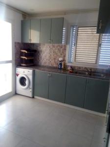 eine Küche mit grünen Schränken und einer Waschmaschine in der Unterkunft Maria Sea view Apartment in Sousse