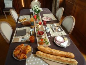 - une table avec du pain et des viennoiseries dans l'établissement Château de Plessier-Roza, à Le Plessier-Rozainvillers