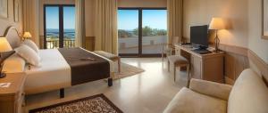 a hotel room with a bedroom with a bed and a television at SH Villa Gadea in Altea