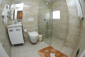 a bathroom with a toilet and a glass shower at Hotel Ramo Saranda in Sarandë
