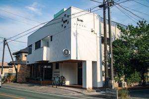 a white building on the side of a street at tune Hostel（ツネホステル館山） in Tateyama