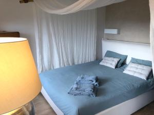 1 dormitorio con 1 cama con sábanas y almohadas azules en Lumio petite maison loft vue mer imprenable, en Lumio