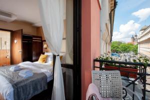 a room with a bed and a balcony with a view at Hotel Wielopole in Krakow