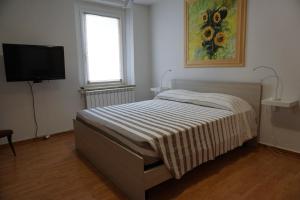 een slaapkamer met een bed en een flatscreen-tv bij A Casa Mia in Romàns dʼIsonzo