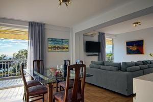 a living room with a glass table and a couch at Amazing Seafront Apartment Athens Riviera in Athens