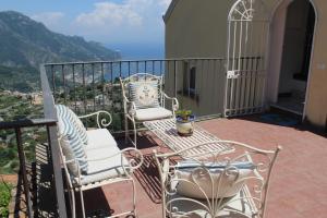 a balcony with two chairs and a view of the ocean at Guest House Malù in Scala