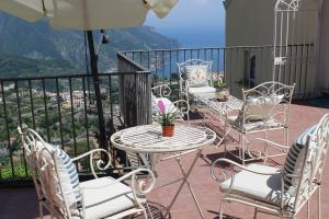 a group of chairs and tables on a balcony at Guest House Malù in Scala