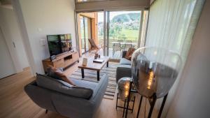a living room with two couches and a television at Seaside-Lodge, Top Apartment in Spiez