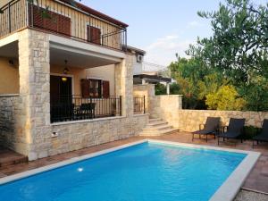 a swimming pool in front of a house at Casa Emma in Krk