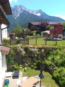 a garden with a table and chairs and mountains in the background at Ferienwohnung Zechner in Waidring