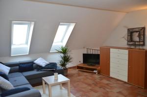 a living room with a blue couch and a tv at Ferienhaus Am Park in Löbnitz