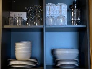 un armadio pieno di piatti, ciotole e bicchieri di Small Vinter Summer House a Käsmu