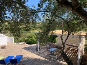 a patio with chairs and a table and a tree at VILLA ARANZOS in Golfo Aranci +26 photos