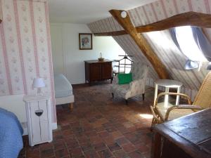 Habitación con cama, silla y mesa. en gite des tisserands en Ferrière-Larçon
