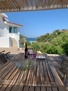 a bottle of wine sitting on a wooden deck at VILLA ARANZOS in Golfo Aranci