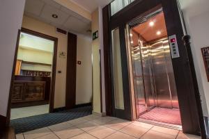 un couloir avec une porte en verre dans un bâtiment dans l'établissement Hotel Gangi, à Piazza Armerina