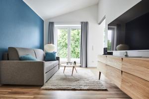 a living room with a couch and a tv at Boardinghome Oldenburg in Oldenburg