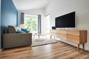 a living room with a tv and a couch at Boardinghome Oldenburg in Oldenburg