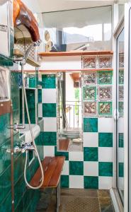 a bathroom with a green and white tiled wall at Studio avec vue panoramique in Puget-Théniers
