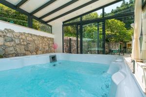 a jacuzzi tub in a house with a large window at Old stone house Mario in Podgora