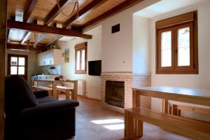 a living room with a fireplace and a table at Albergue Usandi Auto Check-in in Ziortza-Bolibar