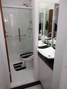 a bathroom with a toilet and two sinks and a shower at Curitiba Central Hostel in Curitiba +23 photos