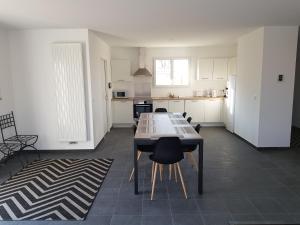 cocina con mesa y sillas en una habitación en Bienvenue à Bordeaux! Parking Pétanque Wi Fi, en Beychac-et-Caillau