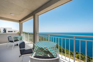 a balcony with chairs and tables and the ocean at Sea Sky Apartment in Cavtat