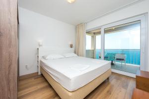 a bedroom with a large bed and a large window at Sea Sky Apartment in Cavtat