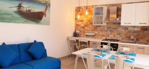 a living room with a table and a blue couch at La Baia Apartments in Torre Lapillo