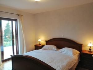 a bedroom with a large bed with two lamps on tables at Casa Emma in Krk +18 photos